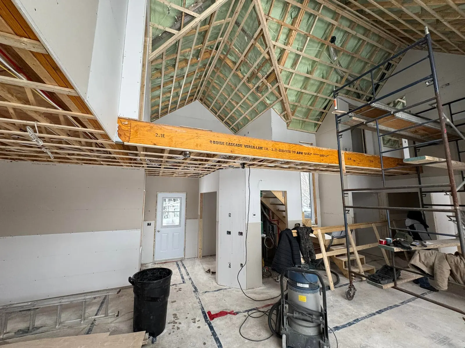 Rez-de-chaussée d'une maison neuve en gypse, avec échafaudage et poutre apparente
